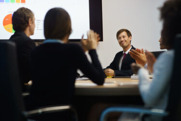 Business People Applauding Manager Doing Presentation In Meeting