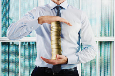 Businessman holds in his hands a stack of coins